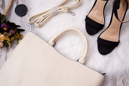 Fashionable concept. Light bag, black shoes and flowers on a white background. Top viewの写真素材