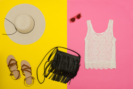 Female wardrobe. White top, handbag, sandals and hat. Bright pink-yellow background. fashion conceptの写真素材
