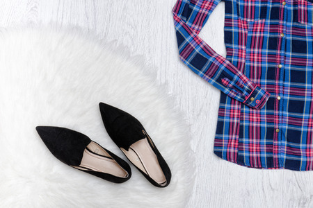 Black shoes on white fur, part of a plaid shirt. Fashionable conceptの写真素材