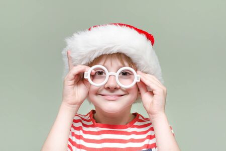 Boy is wearing Santa's glasses and hat. Portraitの写真素材