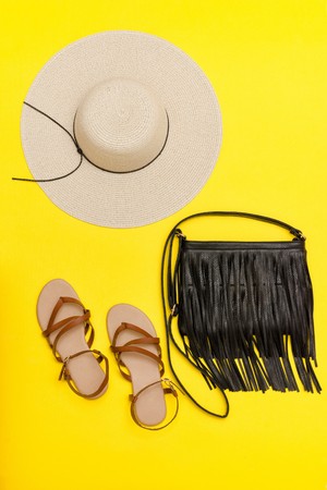 Fashionable concept. Women's beach hat, handbag, sandals. Yellow backgroundの写真素材