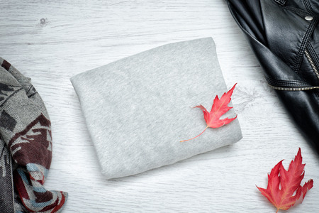 Gray sweater, black jacket, scarf and autumn leaves. Fashionable conceptの写真素材