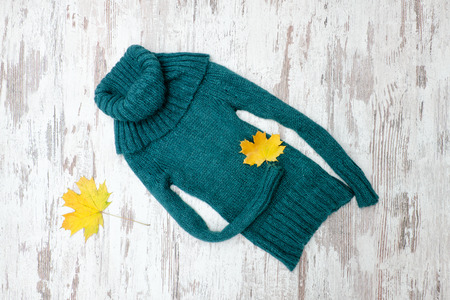 Emerald warm sweater and maple leaves. Fashionable concept.の写真素材