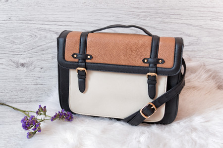 Women's white and brown bag on white fur. Fashionable conceptの写真素材