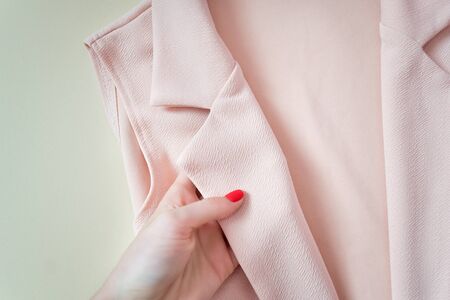 Pink collar jacket in a female hand. Details. Fashionable conceptの写真素材