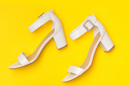 Fashionable concept. White shoes on yellow background, top viewの写真素材