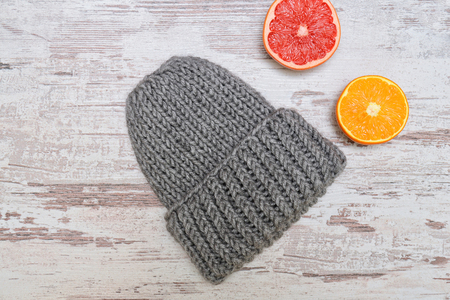 Gray hat. Orange and grapefruit. Wooden background. Winter concept.の写真素材