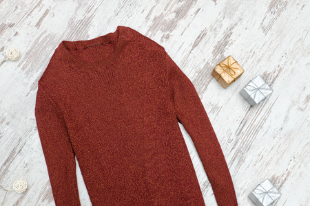Brown sweater and gift boxes on a wooden background. Fashionable conceptの写真素材