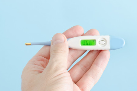 Electronic thermometer in a man's hand. Close-up