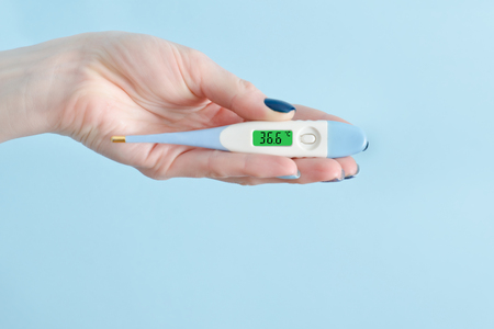 Electronic thermometer in a female hand. Normal temperature. Close upの写真素材
