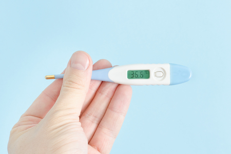 Electronic thermometer in a man's hand. Close upの写真素材