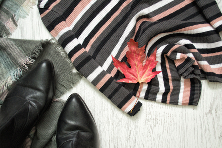 Striped sweater, black boots and red maple leaf. Fashionable conceptの写真素材