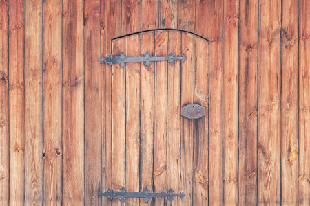 Old wooden doors with forged hinges and a lockの写真素材