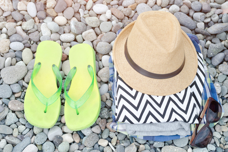Flip-flops,  hat and clothes on pebbles. Travel conceptの写真素材
