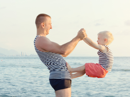 Dad and son are playing on the beach. Fun pastimeの写真素材