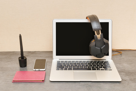 Open laptop, headphones, smartphone and notepad. Workplace Preparation