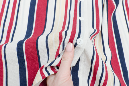 Part striped shirt in a female hand. Close-upの写真素材