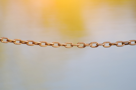 Old metal chain on a blurred yellow background
