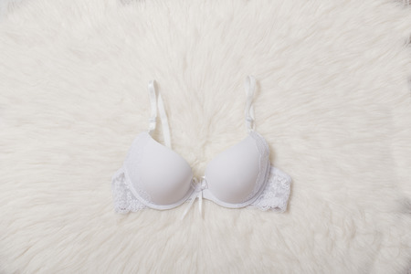 Fashionable concept. Female underwear. White bra with lace on white fur.の写真素材