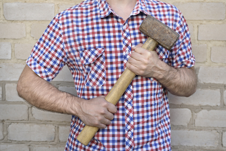 Man with a hammer, on the brick wall background. Working conceptの写真素材