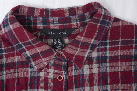 KHARKOV, UKRAINE- OCTOBER 1, 2018: Collar of red checkered shirt on wooden background. NEW LOOKのeditorial素材