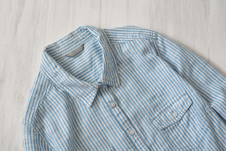 Blue striped shirt on wooden background. Fashionable concept. Clouse upの写真素材