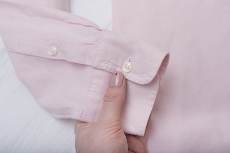 Sleeve of pink shirt in female hand. Fashionable conceptの写真素材