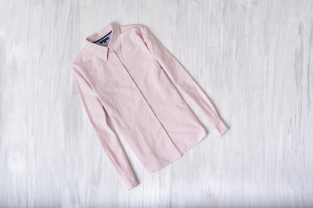 Pink shirt on wooden background. Fashionable conceptの写真素材