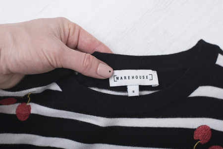 KHARKOV, UKRAINE- NOVEMBER 07, 2018: White label WAREHOUSE in female hand.  Close up. Fashion conceptのeditorial素材