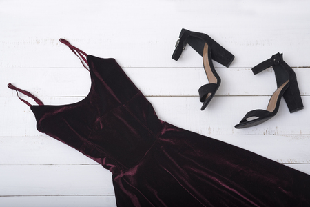 Velvet burgundy dress and shoes on wooden background. Fashionable conceptの写真素材