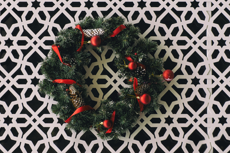 Christmas wreath with red ribbons hanging on the wall with carved ornament.の写真素材