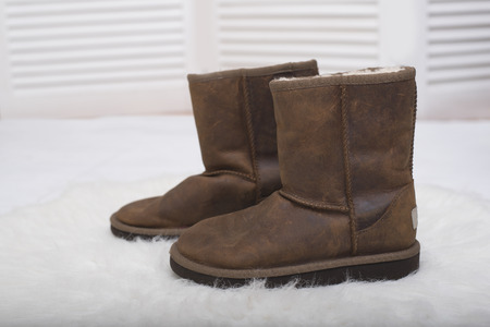 Winter brown boots on white fur. Fashion conceptの写真素材