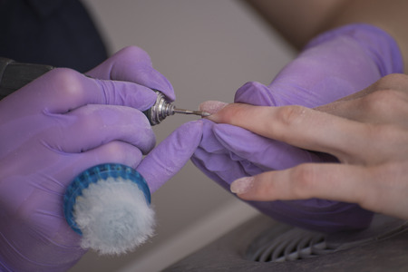 Processing nails on hands, mill for manicure. Close upの写真素材