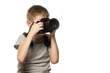 Boy takes pictures on the camera. Portrait. Isolate on white background.の写真素材