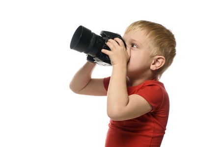 Young blond boy with camera. Portrait, isolated on white background. Side viewの写真素材