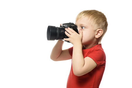 Young blond boy with camera. Portrait, isolated on white background. Side viewの写真素材