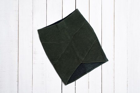 Green short skirt on white wooden background. Fashion concept.の写真素材