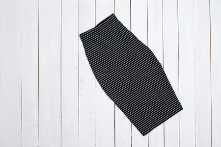 Black striped skirt on white wooden background. Fashion concept.の写真素材