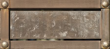 Vintage rectangular plate in metal frame with rivets.