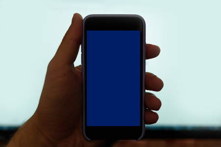 Male hand with a smartphone. Black blank screen. White backgroundの写真素材