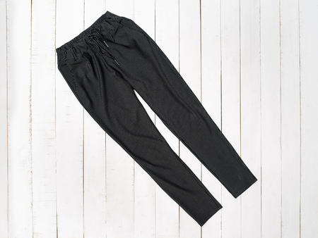 Black pants on white wooden background.. Top view.の写真素材