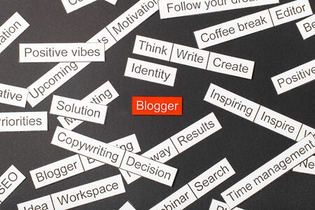 Cut paper inscription blogger on a red background, surrounded by other inscriptions on a dark background. Word cloud conceptの写真素材