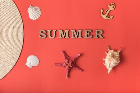 Word Summer from wooden letters. Seashells, anchor and part of a hat. Live coral background. Marine conceptの写真素材
