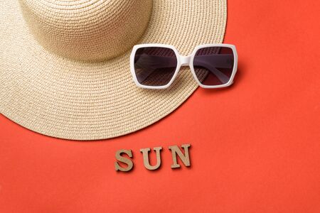 Word Sun from wooden letters. Sun glasses and hat. Live coral background. Travel conceptの写真素材