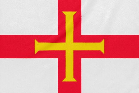 Flag of Guernsey on textured fabric. Patriotic symbolの写真素材