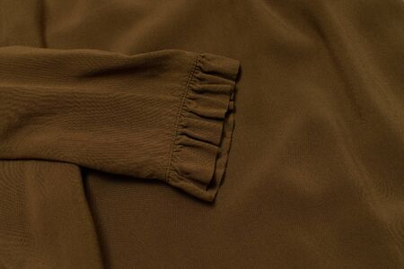 Clothes fashion concept. Sleeve of khaki blouse. Top view