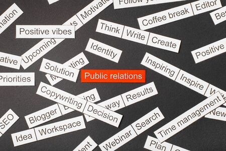 Cut paper inscription public relations on a red background, surrounded by other inscriptions on a dark background. Word cloud conceptの写真素材