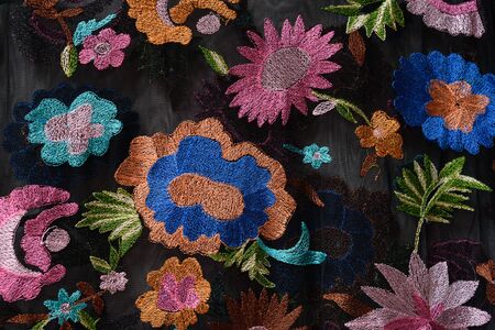 KHARKOV, UKRAINE - APRIL 27, 2019: Bright flowers embroidered on black fabric. Close-upのeditorial素材