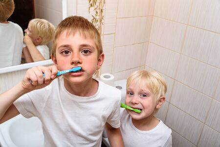 Two boys thoroughly brush their teeth in the bathroom. Morning hygieneの写真素材