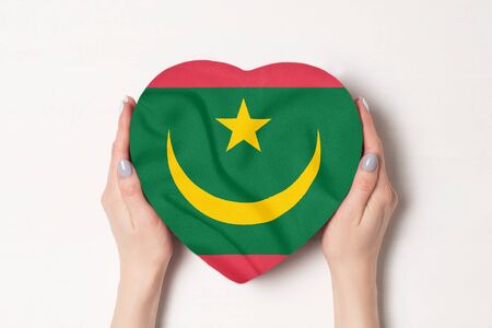 Flag of Mauritania on a heart shaped box in a female hands. White backgroundの写真素材